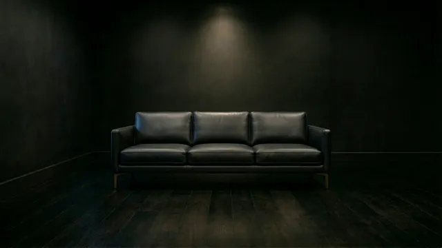暗闇に佇む黒い3シーターレザーソファ