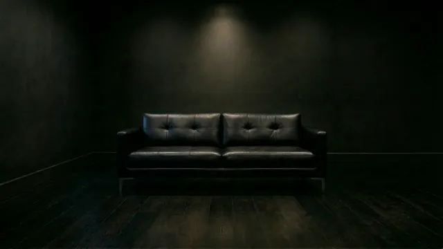 暗闇に佇む黒いレザーソファ