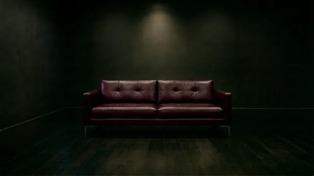 暗闇に佇むワインレッドの3シーターレザーソファ 2